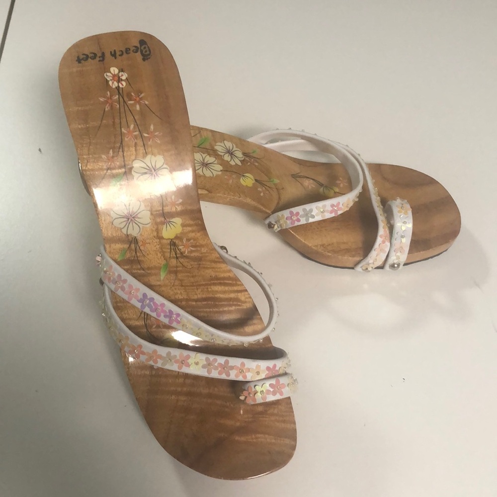 Handmade wooden clogs with painted details and sequin straps.